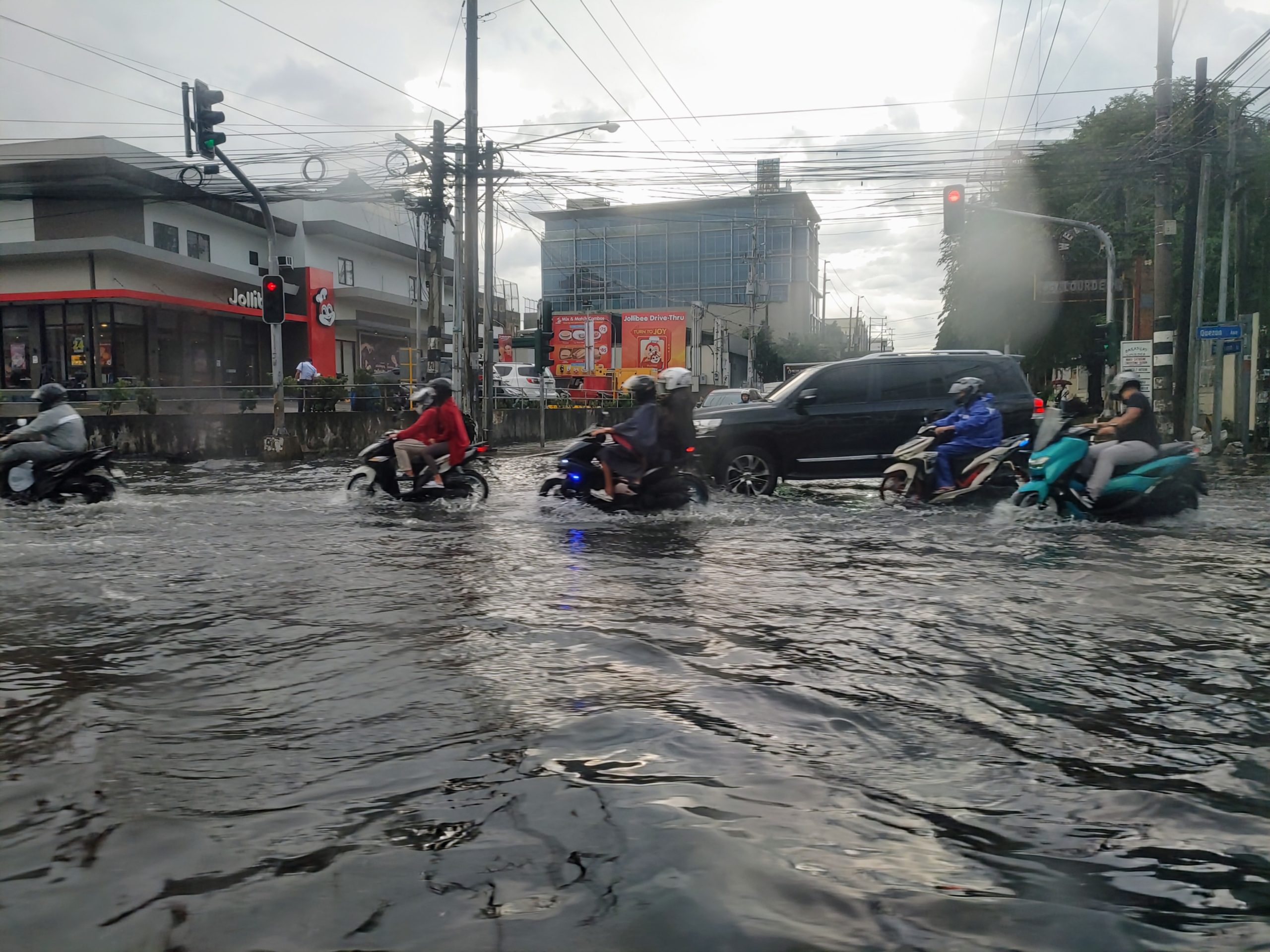 Motorists driving through the floodwaters on Quezon Avenue after minutes of moderate rain. Photo taken by Lester Naguna PIA-NCR.