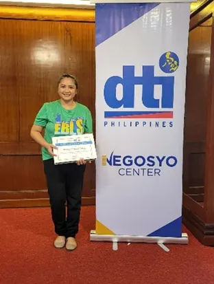 Marie Claire Bince proudly displays her Enhanced Business Learning Session (EBLS) certificate, a testament to her dedication to improving her business through government programs. (Photo courtesy of DTI-10)